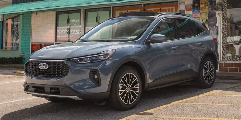 A grey 2026 Ford Escape parked out in front of a shop.